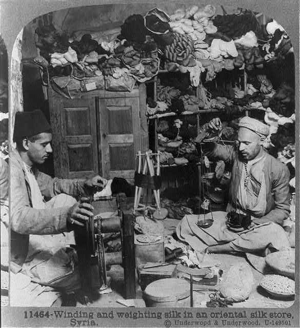 Winding and weighting silk in an oriental silk store, Syria