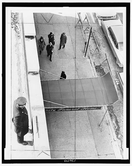 Policeman maintains watch from roof of Unity funeral home...