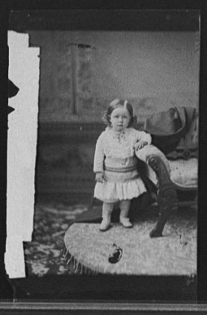 [Girl, posed by chair]