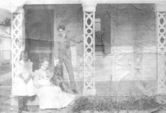Emma Halkett on porch with unknown children