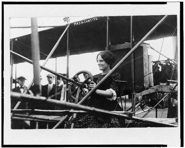 [Mrs. Glenn Curtiss at the controls of an airplane]