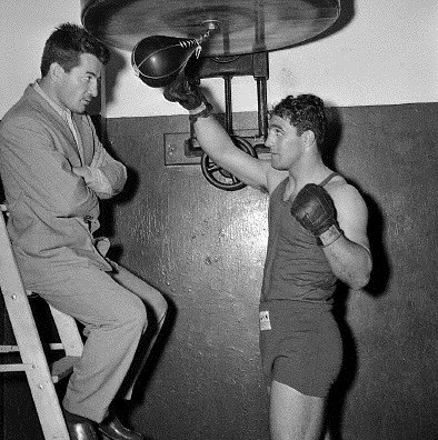 Rocky Graziano on ladder and Rocky Marciano in gloves.