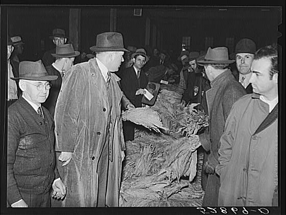 Warehouseman and auctioneer with buyers in background...