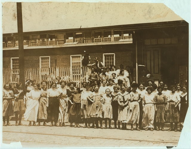 [Groups of girls workers at the gate of the American...