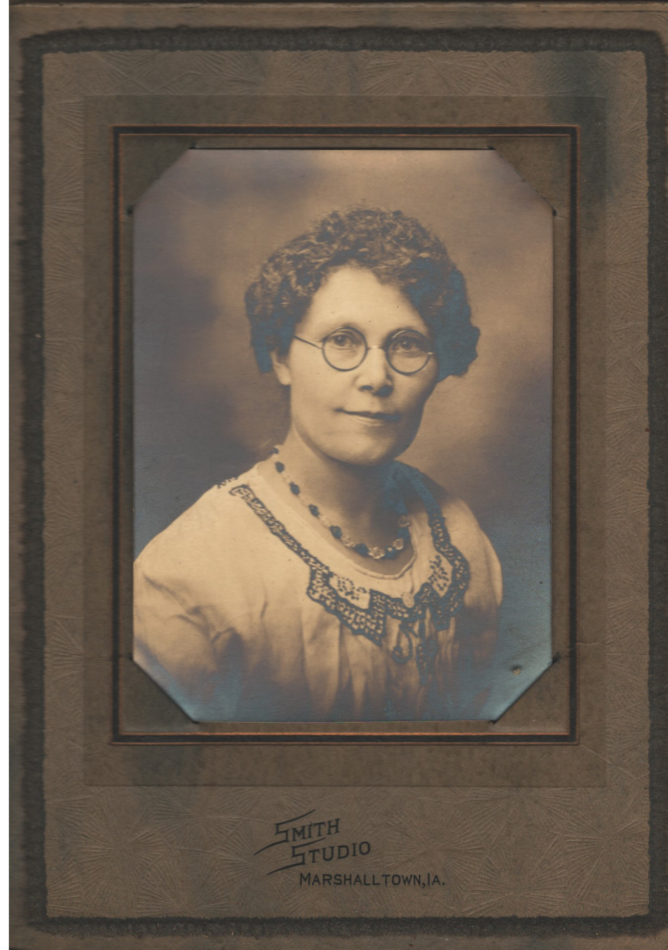 Woman with short curly hair and glasses