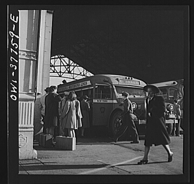 Indianapolis, Indiana. An old-type bus being boarded by...