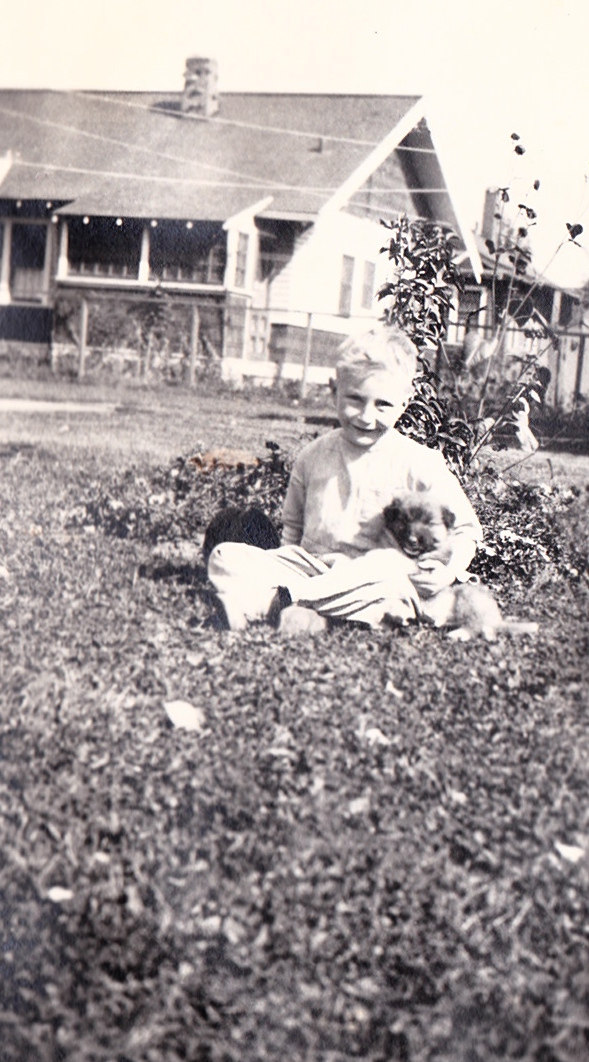 Boy on lawn with puppy