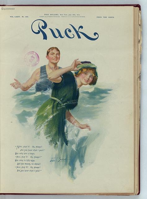 [Young man splashing a young woman with water at the...