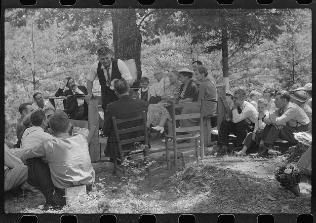 Preacher, relatives and friends of the deceased at a...