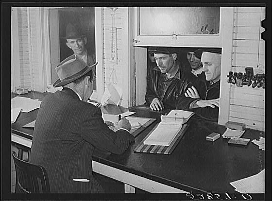 Farmers getting their checks in warehouse office after...