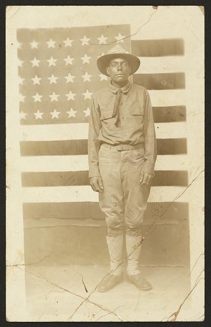 [World War I soldier with American flag in background]