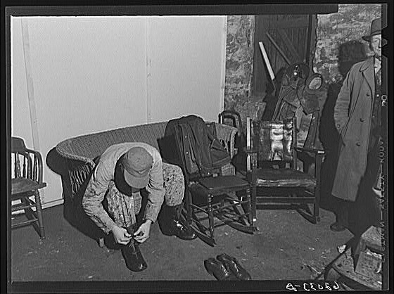 Constuction worker putting on overshoes in basement of...