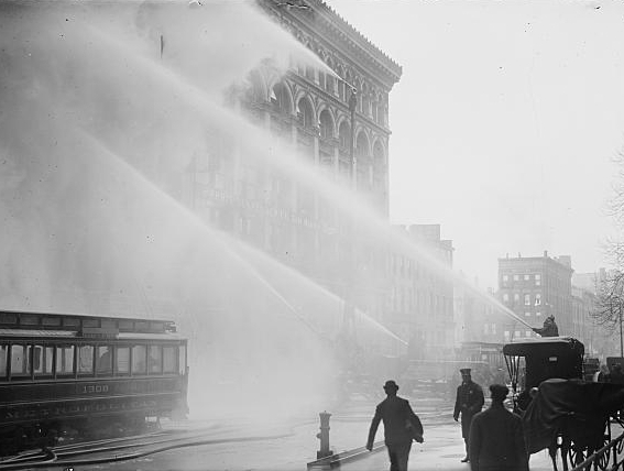 Firemen spraying burning building, NY