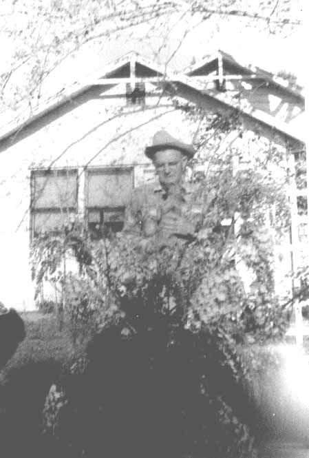 Papa "Pat" Patterson in front of his wysteria bush