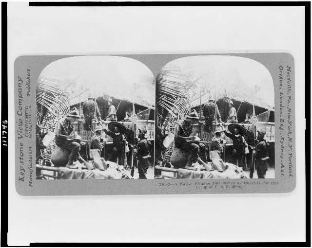 A native Filipino hut serves as quarters for this group...